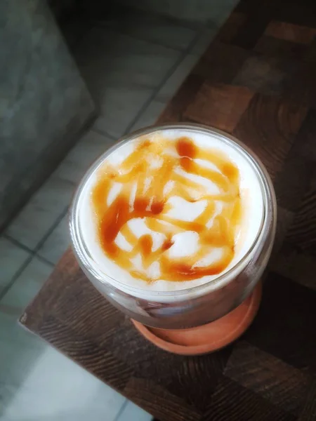 氷のガラス塩キャラメルマキアート ミルクとキャラメルシロップをミックスしたコーヒーはとてもフレッシュで 少し苦みがあり 塩気があり 暑い日にはとてもおいしいです — ストック写真