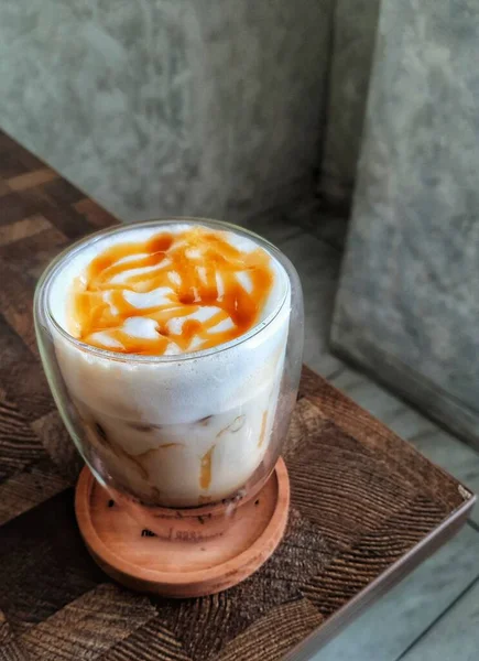 Glass of Ice Salted Caramel Macchiato. Coffee with a mixture of milk and caramel syrup which is very fresh, sweet, slightly bitter and salty is very delicious enjoyed on a hot day.