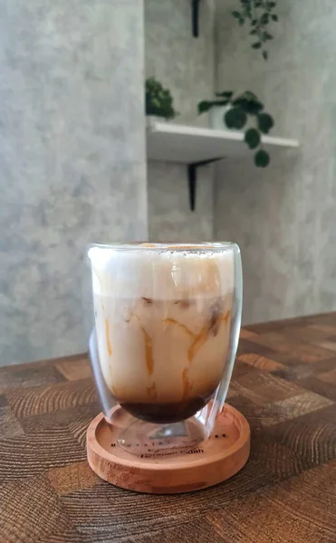 Glass of Ice Salted Caramel Macchiato. Coffee with a mixture of milk and caramel syrup which is very fresh, sweet, slightly bitter and salty is very delicious enjoyed on a hot day.