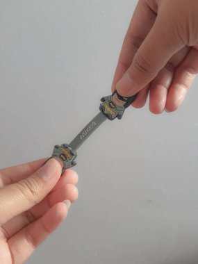 Cakarta, Endonezya Temmuz 2021. Bir el, katlanmış kabloları düzeltmeye yarayan Batman görüntüsü olan bir kablo tutacağı tutuyor. Böylece dağınık olmuyorlar..