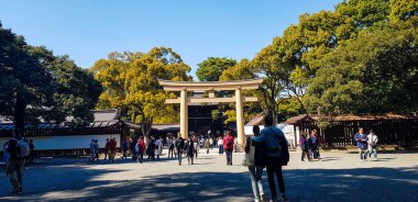Japonya 2019 Nisan 'ında. Harajuku Şehir Ormanı 'nın girişinden Meiji Tapınağı' na doğru yürüyen turistler. Meiji Tapınağı Yoyogi Parkı ve Harajuku Şehir Ormanı ile ünlüdür..