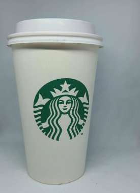 Batı Java, Endonezya Ekim 2022. Büyük boy Starbuck logosu olan beyaz bir kağıt bardak sıcak içecekler için kullanılır..