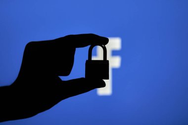 Taşkent, Özbekistan - 7 Ekim 2021: Facebook logosu üzerinde asma kilit tutan bir kişinin silueti. Facebook bloğu, kısıtlama veya sansür kavramları. Facebook kesintisinin sembolü