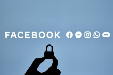 Taşkent, Özbekistan - 7 Ekim 2021: Facebook logosu üzerinde asma kilit tutan bir kişinin silueti. Facebook bloğu, kısıtlama veya sansür kavramları. Facebook kesintisinin sembolü