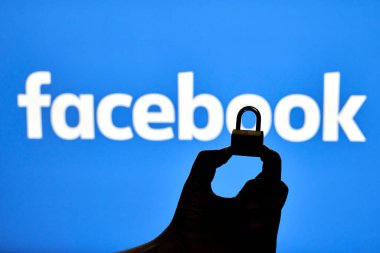 Taşkent, Özbekistan - 7 Ekim 2021: Facebook logosu üzerinde asma kilit tutan bir kişinin silueti. Facebook bloğu, kısıtlama veya sansür kavramları. Facebook kesintisinin sembolü