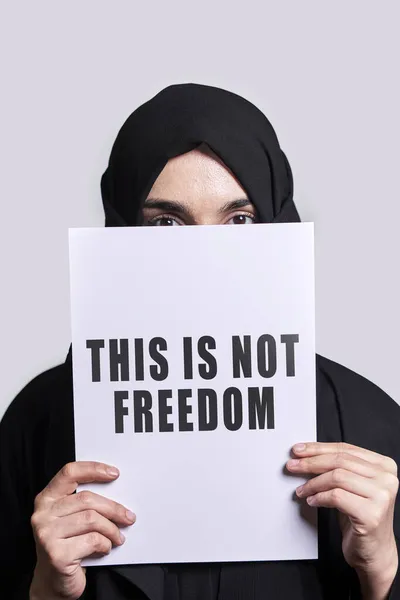 Muslim woman holding a paper with text - This is not freedom — Stock Photo, Image