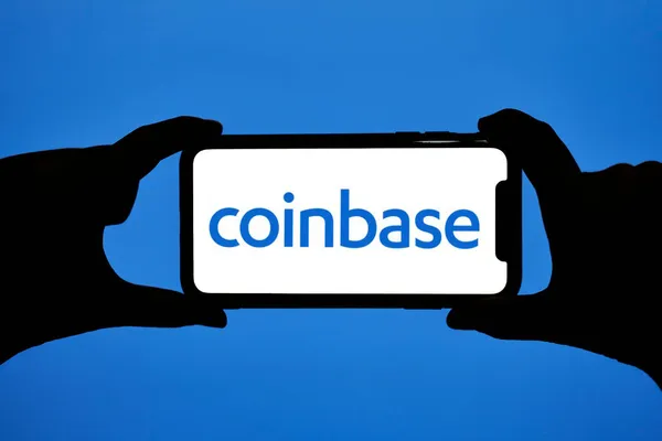 Hände halten Smartphone mit Coinbase-Logo — Stockfoto