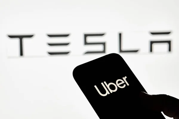 Tesla logolu Uber marka akıllı telefonu olan bir kişi