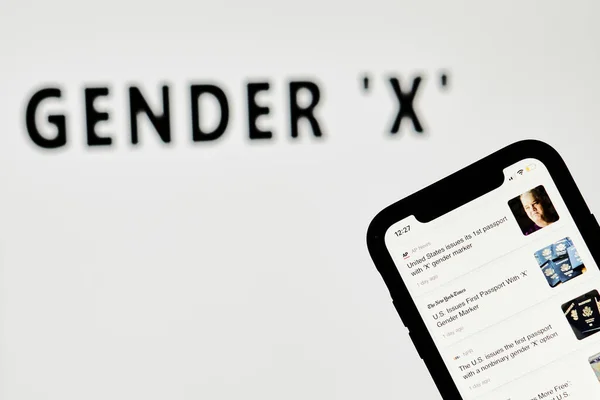Person blättert in Neuigkeiten über neue US-Pässe mit X-Gender-Marker — Stockfoto