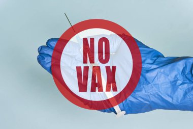 Antivaxxer şırınganın yanında Covid-19 aşısıyla el ele tutuşuyor.