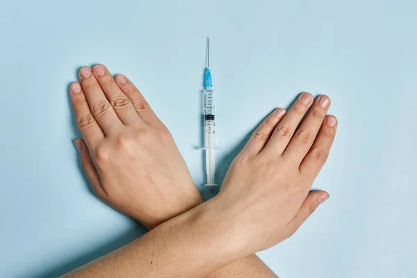 Antivaxxer crossing hands near the syringe with Covid-19 vaccine — Stock Photo, Image