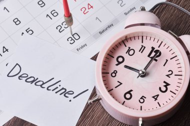 Kağıt, alarm saati ve aylık takvim üzerindeki son teslim tarihi