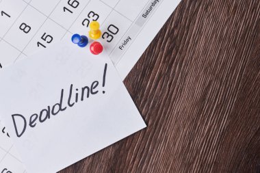 Teslim tarihi konsepti. Aylık takvime iliştirilmiş son teslim tarihi olan bir kağıt