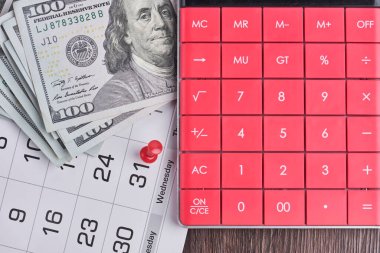 Hesap makinesi, dolar ve aylık takvim. Maaş günü, son gün konseptleri.