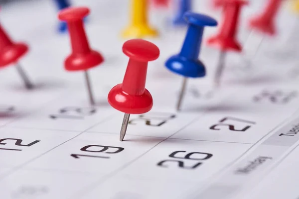 Colored push pins on monthly calendar page — Stock Photo, Image