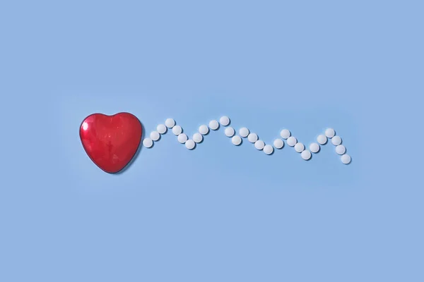 薬局の概念 青い背景に心臓と心臓のリズムの形をした薬と薬 — ストック写真