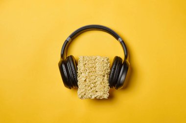 Anında erişte kompozisyonu. Sarı arka planda erişte ve kulaklık.