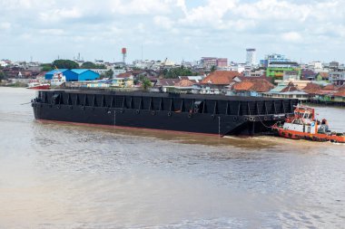 Palembang, Indonesia - August 2022: a barge that often crosses the Musi River, this ship usually carries coal, sand, and other materials