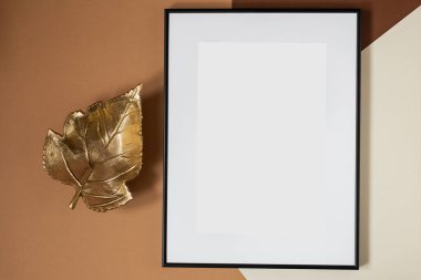 Black picture frame with decorations. Mock up for your photo or text. Place your work, print art, white background. Photo realistic 3d illustration. Brown background