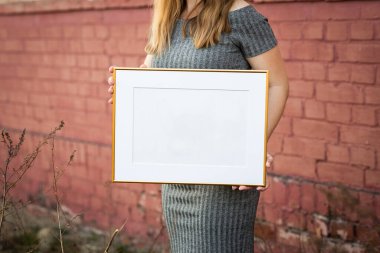 Süslemeli beyaz resim çerçevesi. Fotoğrafın ya da mesajın için hazırlan. Eserlerinizi yerleştirin, baskı sanatı, beyaz arka plan, pastel renk kitabı. Fotogerçekçi 3D çizim. Çerçeve tutan kız