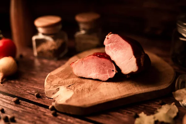 Meat on a wooden table with addition of fresh herbs and aromatic spices. Natural product from organic farm, produced by traditional methods