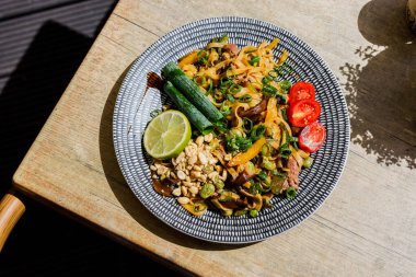 Biftekli Asya eriştesi, domates, ahşap arka plan