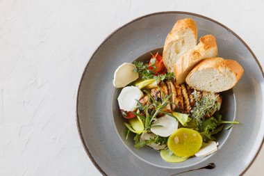 Izgara tavuk göğsü. Kızarmış tavuk fileto ve taze sebze salatası, domates, salatalık ve roka yaprakları. Tavuk et salatası. Sağlıklı gıda. Düz yatıyordu. Üstten Görünüm. Beyaz arka plan