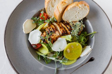 Izgara tavuk göğsü. Kızarmış tavuk fileto ve taze sebze salatası, domates, salatalık ve roka yaprakları. Tavuk et salatası. Sağlıklı gıda. Düz yatıyordu. Üstten Görünüm. Beyaz arka plan