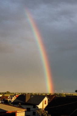 Gökkuşağı mavi gökyüzünde. Rüzgar enerjisi, Polonya. Polonya 'da enerji çiftliği. Gökkuşağı ve rüzgar tarlasıyla manzara