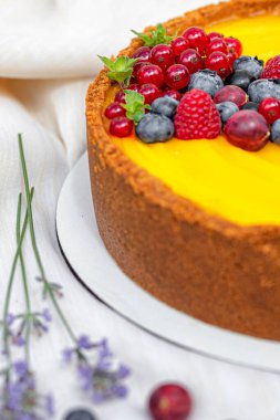 Taze böğürtlenli kek ve yeşil yapraklı beyaz tabakta yaban mersini.