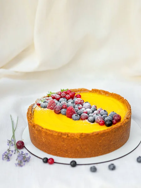 Beyaz tabakta böğürtlenli ev yapımı peynirli kek.