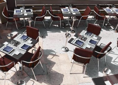 Empty outdoor terrace in a luxury restaurant, prepared with everything you need for lunch or dinner, even the ice bucket waiting for customers on the summer terrace.