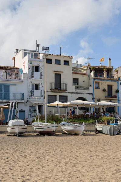 Blanes, Katalonya, İspanya -4 Ağustos 2022: Kosta Brava 'nın kıyı kasabasındaki evler, önünde balıkçı tekneleri ve İspanya' da dalgalanan Katalonya bayrağı.