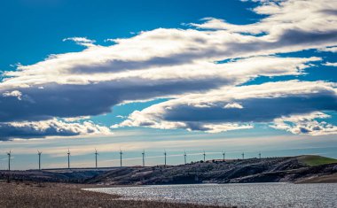 Landscape of windmills in the background next to the Ricobayo reservoir in Montamarta (Zamora - Spain) on a day with many clouds