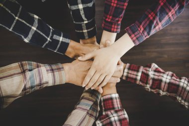 Avuçlarını birbirine kenetleyen bir grup benzer fikirli insan.