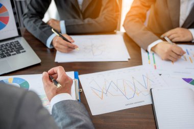 Group professional business people person working together to analyze in office, work together to discuss company financial statistics report, brainstorm ideas, and graph datum documents on the table.