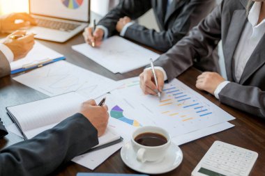 Group professional business people person working together to analyze in office, work together to discuss company financial statistics report, brainstorm ideas, and graph datum documents on the table.