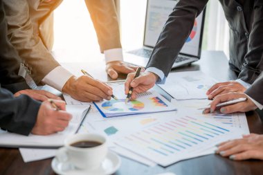 Group professional business people person working together to analyze in office, work together to discuss company financial statistics report, brainstorm ideas, and graph datum documents on the table.