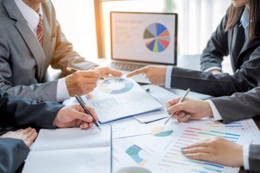 Group professional business people person working together to analyze in office, work together to discuss company financial statistics report, brainstorm ideas, and graph datum documents on the table.