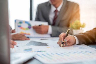 Group professional business people person working together to analyze in office, work together to discuss company financial statistics report, brainstorm ideas, and graph datum documents on the table.