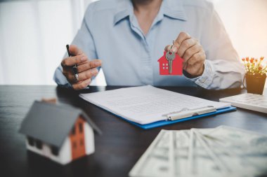 Real estate agent offer hand holding house model with key for customer and buy or sell home. Mortgage loan approval home loan and insurance concept. Copy space