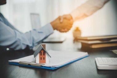 Estate agent shaking hands with client after contract signature and done business deal for transfer right of property. Man broker realtor real estate agent shake hands of happy clients homeowners