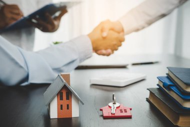 Estate agent shaking hands with client after contract signature and done business deal for transfer right of property. Man broker realtor real estate agent shake hands of happy clients homeowners