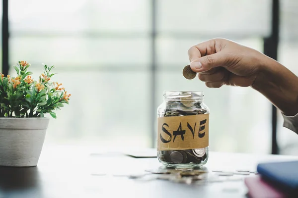 woman hand putting money into jar for saving money wealth and financial concept.