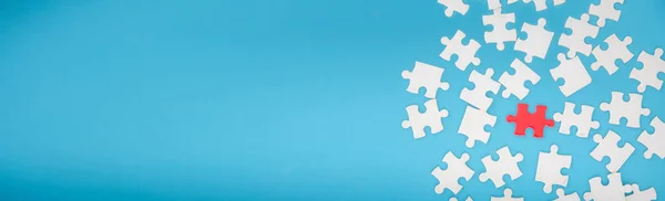 Top view of jigsaw puzzle on blue background and blue banner background with copy space.