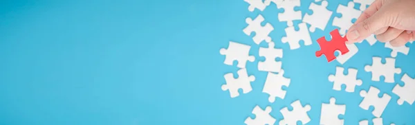 Top view of jigsaw puzzle on blue background and blue banner background with copy space.