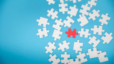 Mavi arkaplanda bitmemiş beyaz yapboz parçaları, yapbozun son parçası, uzayı kopyala..