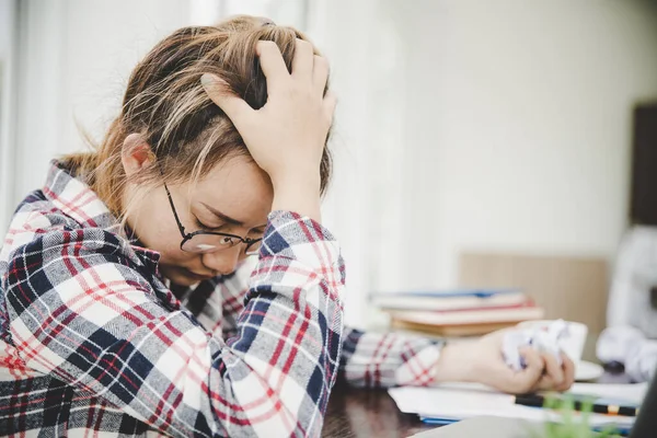 Young frustrated woman working at office desk in front of laptop suffering from chronic daily headaches, treatment online, appointing to a medical consultation, electromagnetic radiation, sick pay