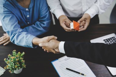 Emlakçı ev satın alma anlaşmasının şartları hakkında konuştu ve müşteriden sözleşmeyi yasal hale getirmek için belgeleri imzalamasını istedi, ev satışları ve ev sigortası kavramı.