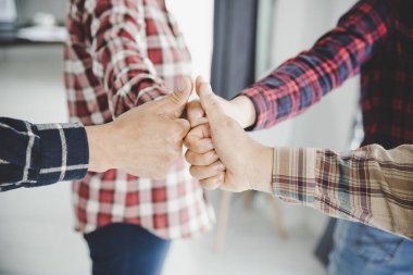 Avuçlarını birbirine kenetleyen bir grup benzer fikirli insan.